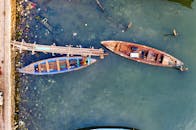 一张航拍照片显示，清澈的水面下，一艘木制渔船正系在乡村码头旁