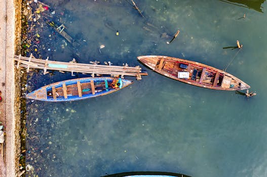 一张航拍照片显示，清澈的水面下，一艘木制渔船正系在乡村码头旁