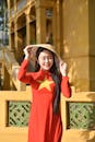 Woman in Red Ao Dai with Traditional Hat Outdoors