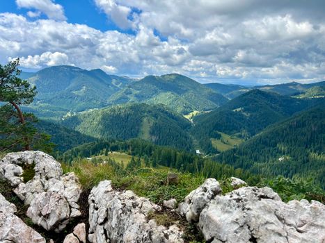 An expansive view of lush green forested mountains under a cloudy sky.