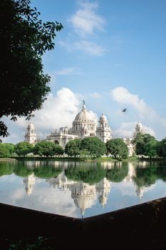 Captivating view of Victoria Memorial reflected in water on a clear day in Kolkata.