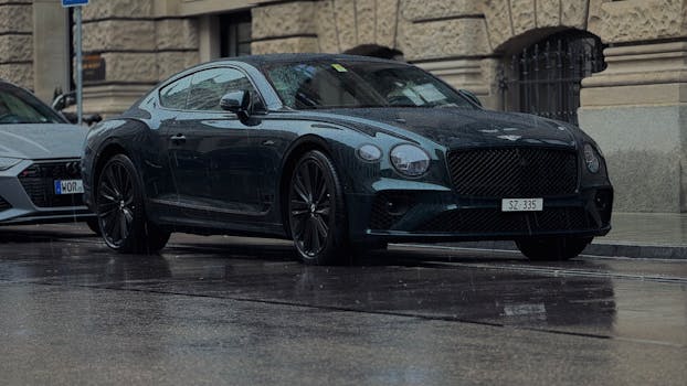 A sleek luxury car parked on a rainy street in Munich, showcasing elegant design under overcast skies.