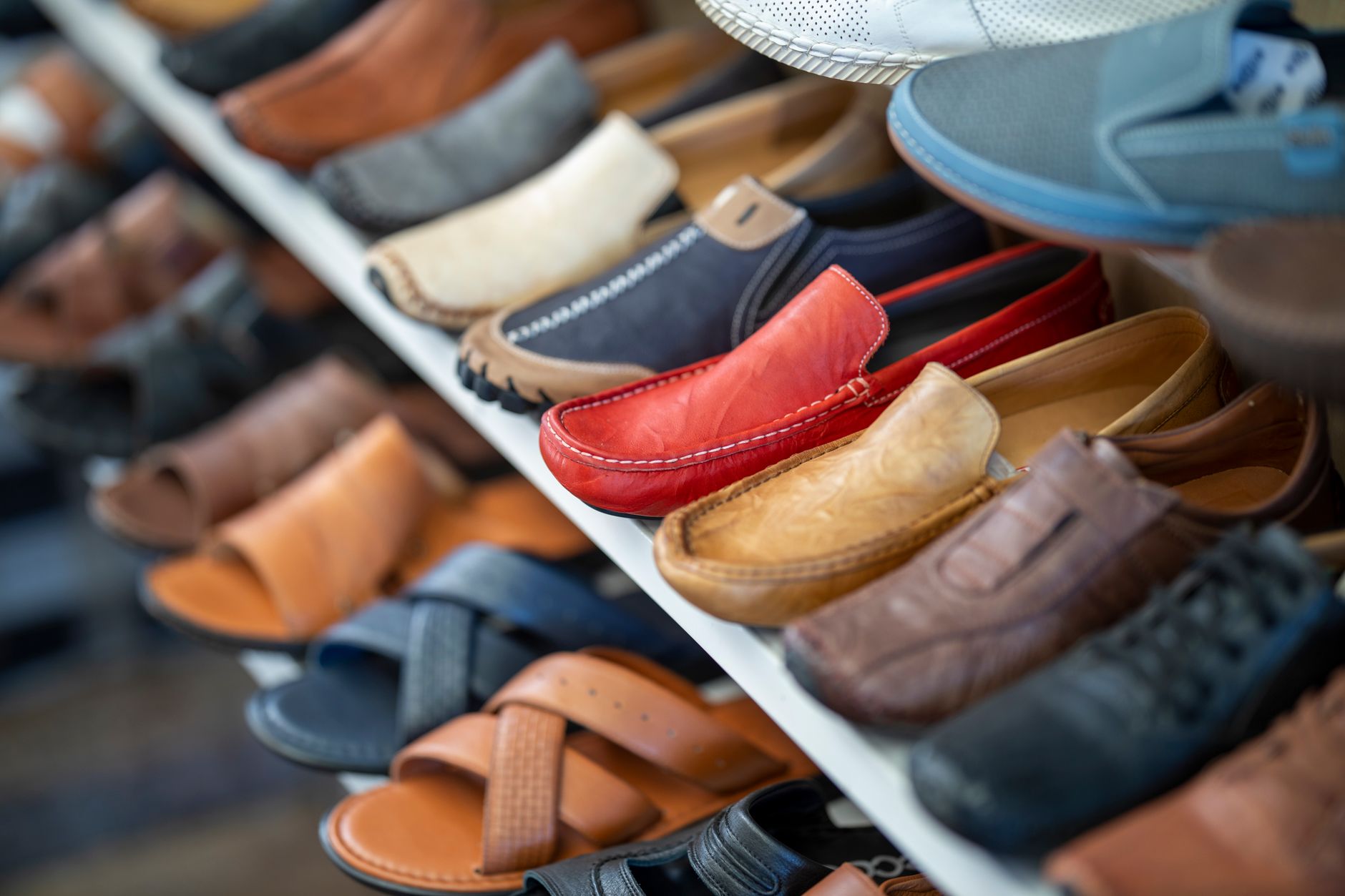 A variety of colored clothes displayed in a retail stall