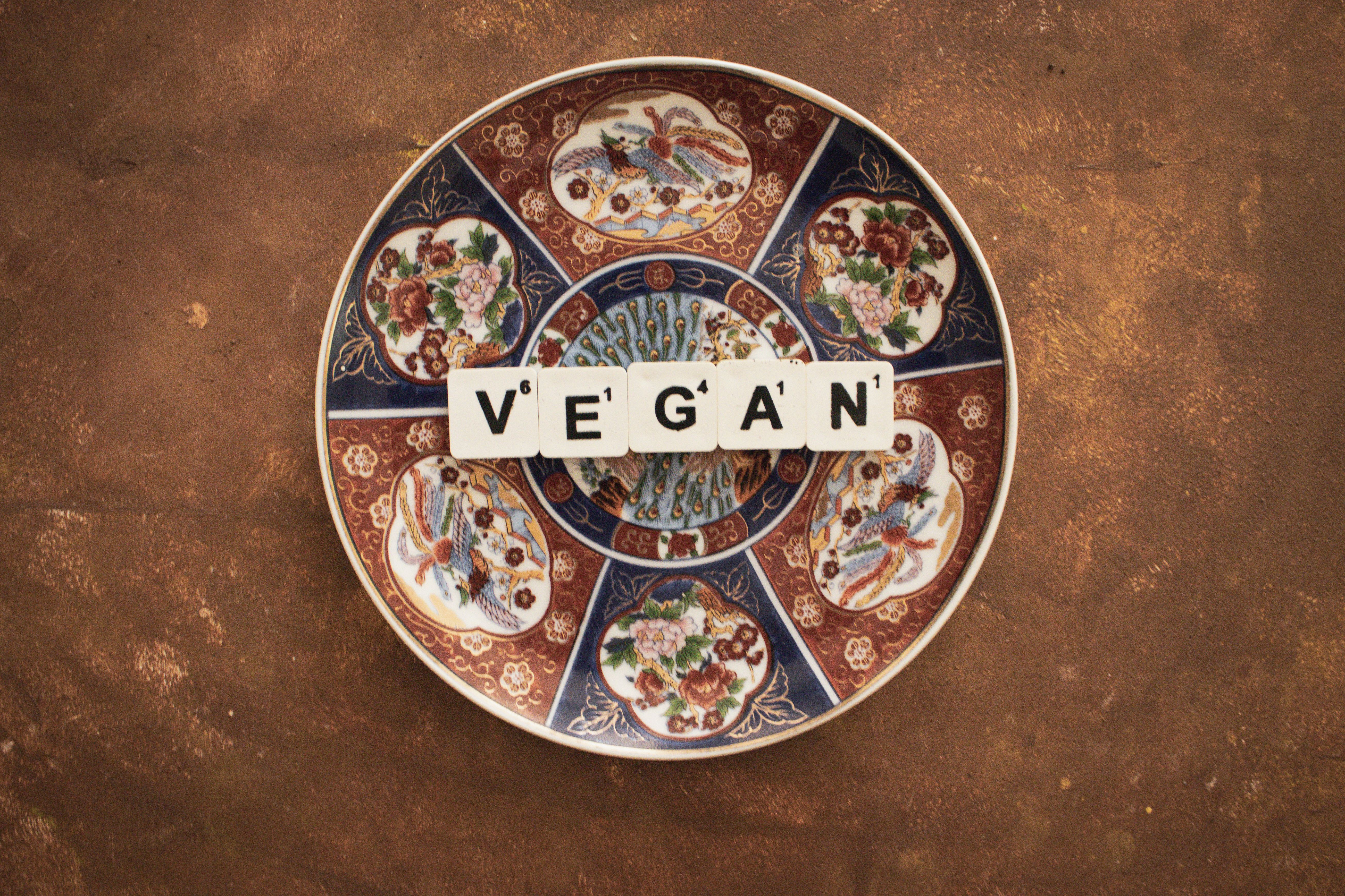 Artistic plate with 'VEGAN' text, promoting plant-based lifestyle.