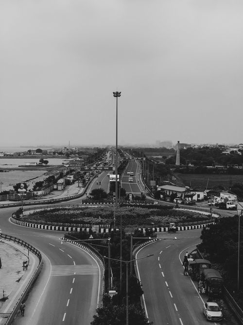 Free A captivating black and white aerial view of a highway and cityscape with dramatic tones. Stock Photo