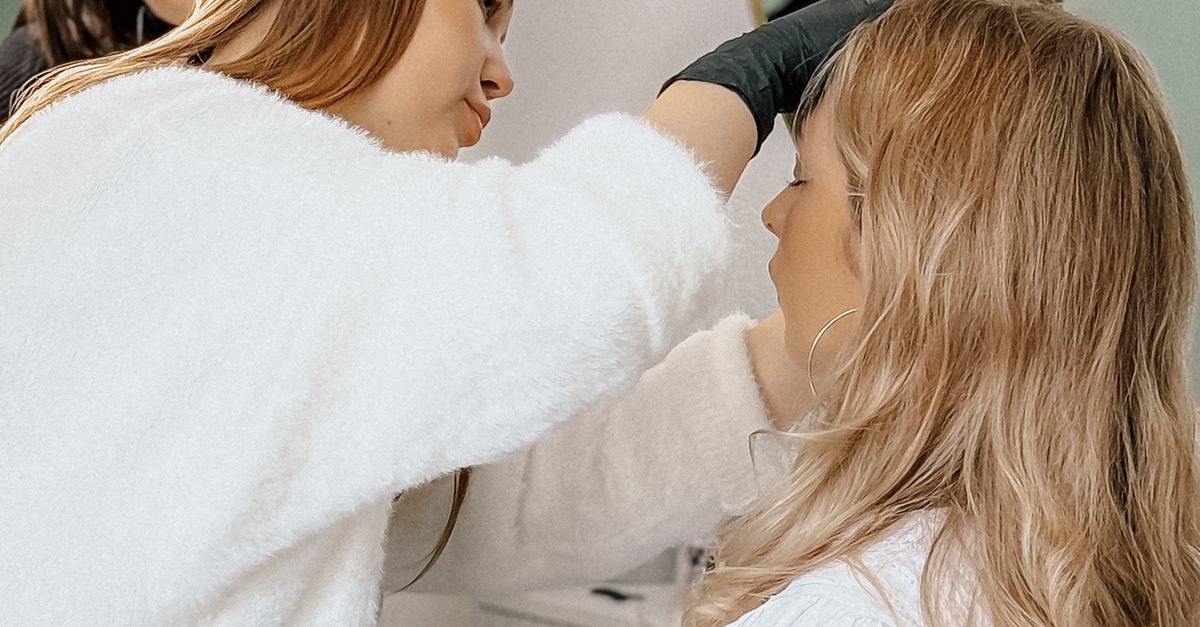 Makeup Getting Applied Woman Getting Makeup Applied in Salon Setting · Free Stock Photo