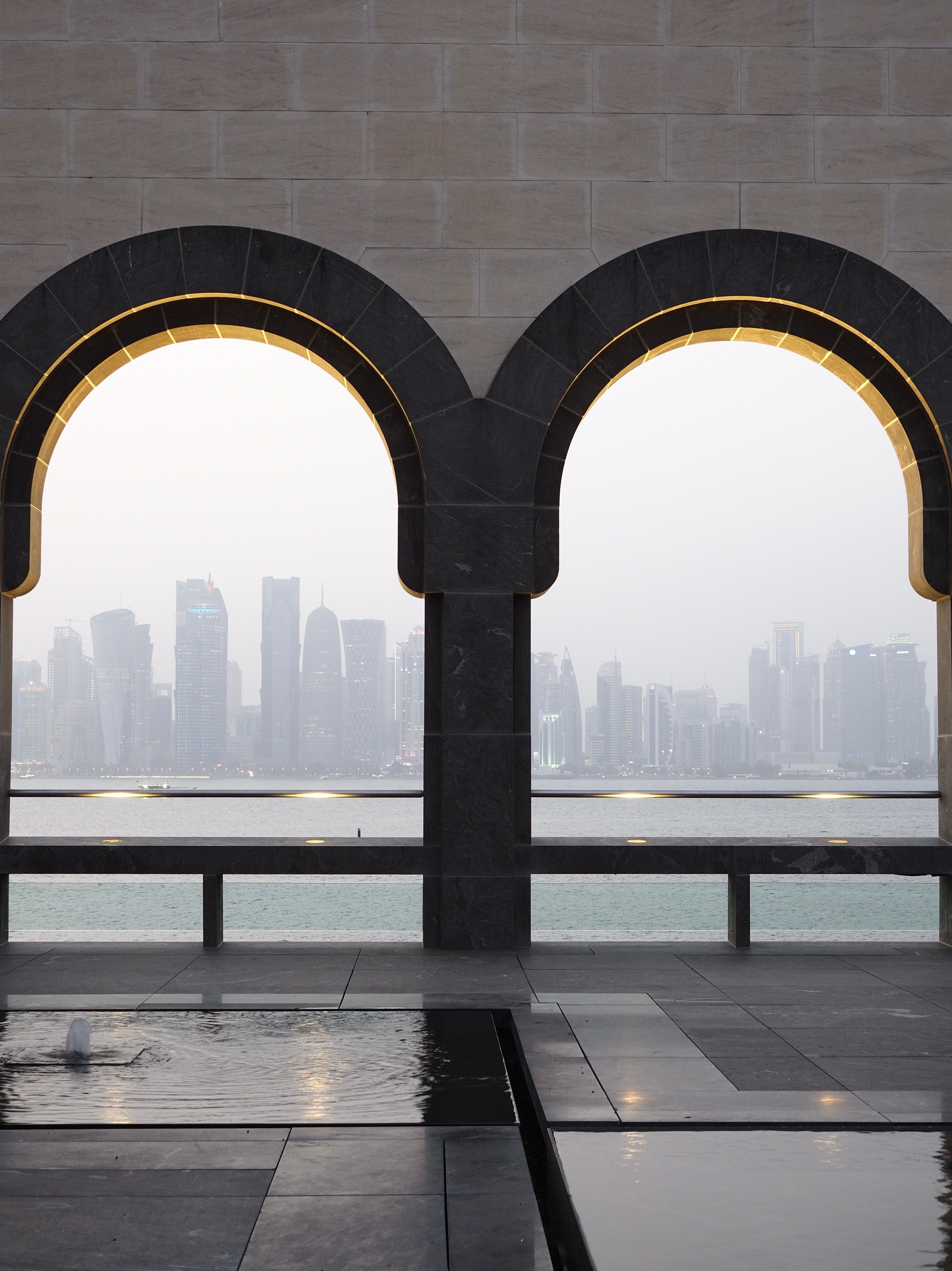 Doha Skyline Through Architectural Arches · Free Stock Photo