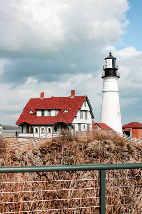 Free Iconic Portland Head Light on a rocky coastline with a dramatic sky in Cape Elizabeth, Maine. Stock Photo