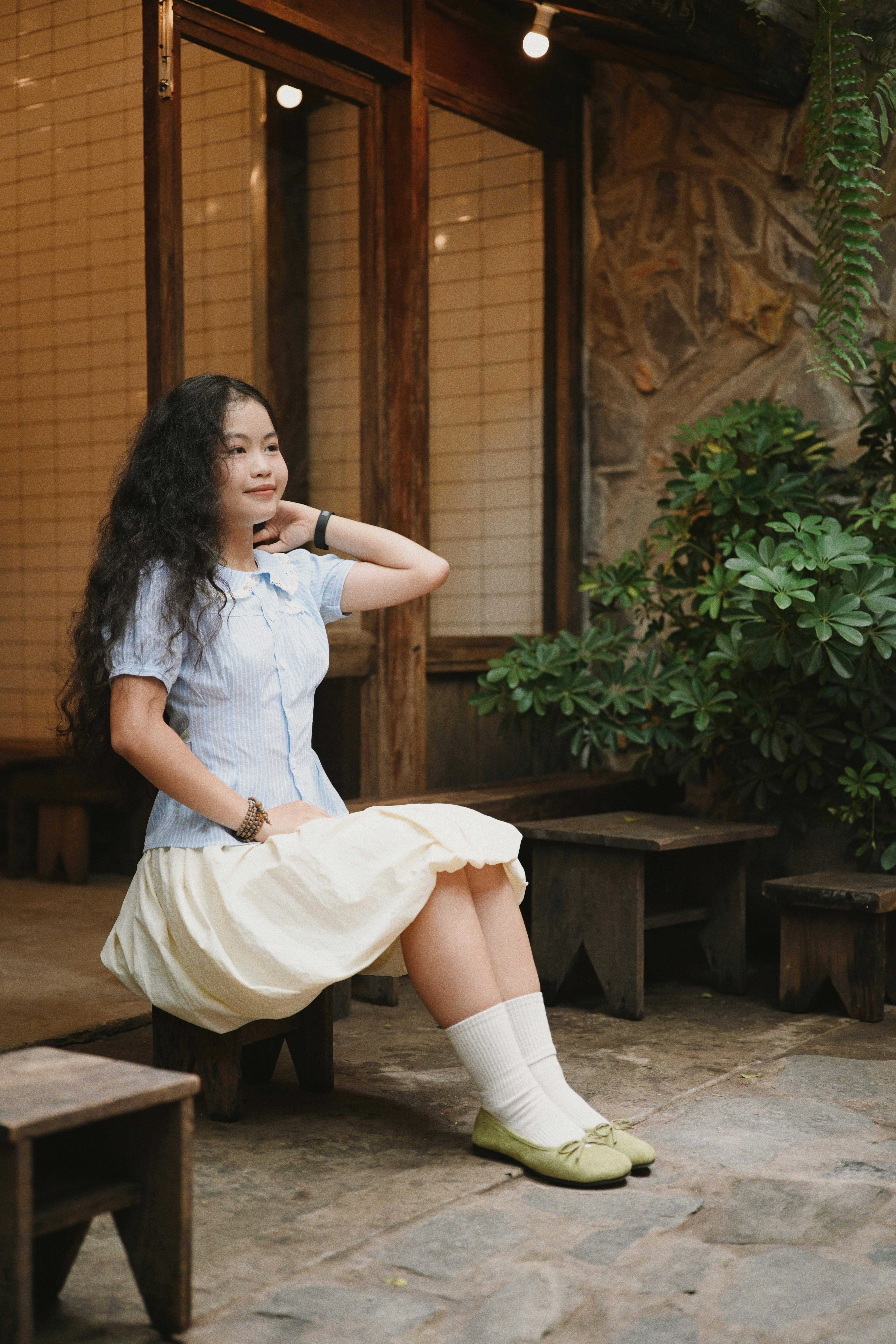 Gratuit Femeie în ținută vintage așezată într-o cafenea rustică confortabilă, bucurându-se de un moment senin. Fotografie de stoc