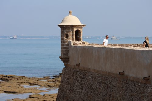 Free A scenic view of a historic fort wall facing the calm sea in Cádiz, Spain, on a sunny day. Stock Photo