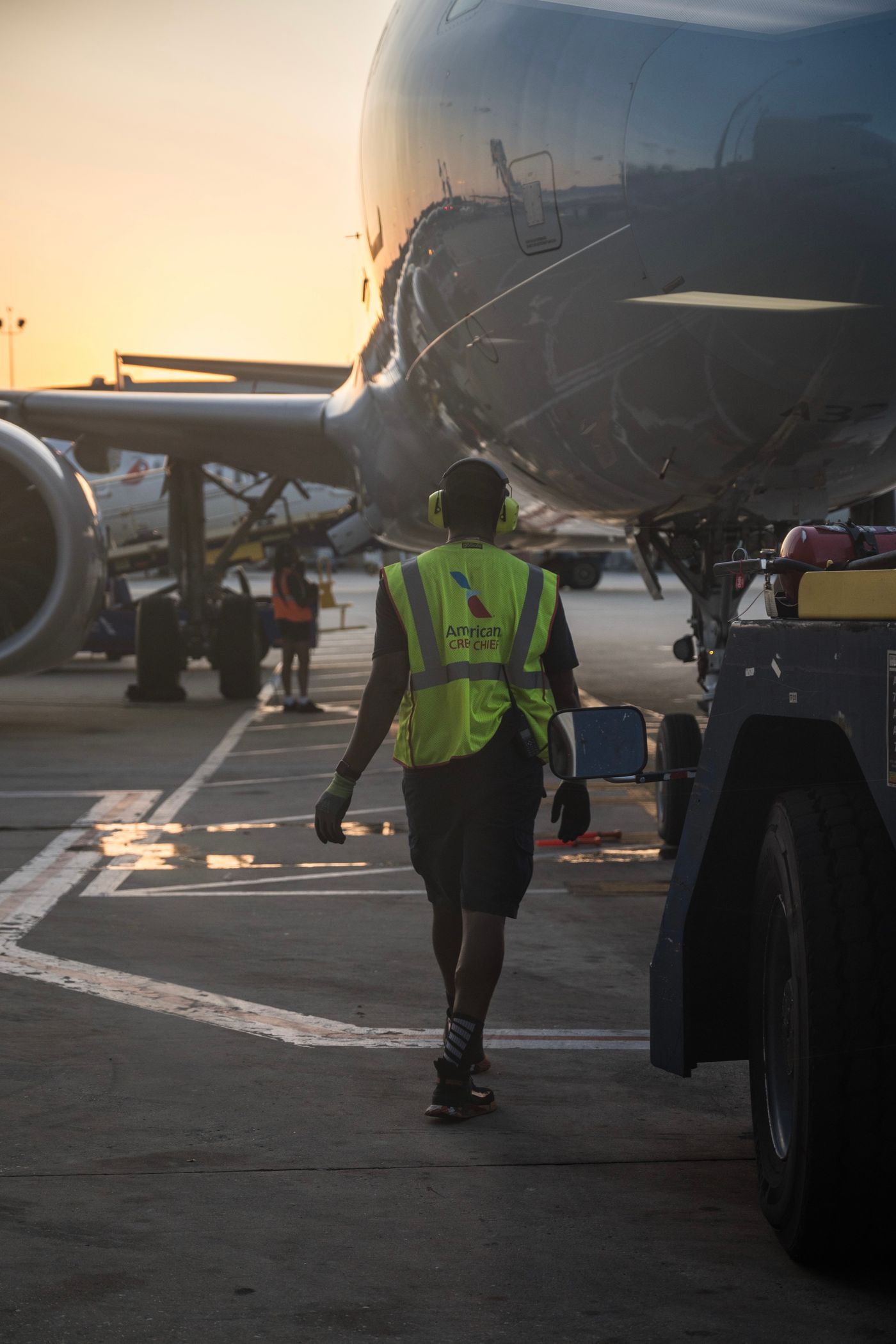 Aviation ground crew at airport during sunset, ensuring aircraft readiness