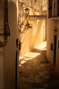 Atmospheric sunlit alleyway with rustic charm in Mediterranean village setting.