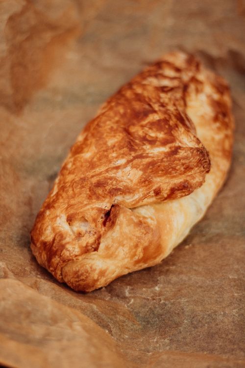 Free A golden, flaky pastry resting on brown baking paper, freshly baked and homemade. Stock Photo