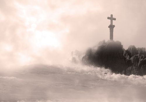 Moody image of a cross on rocks amidst crashing waves and misty seas.