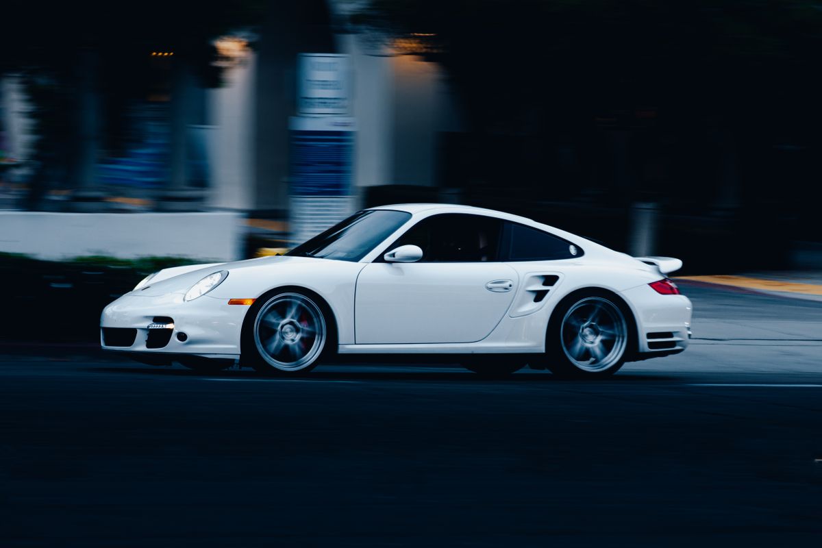 White sports car in motion at night, urban street