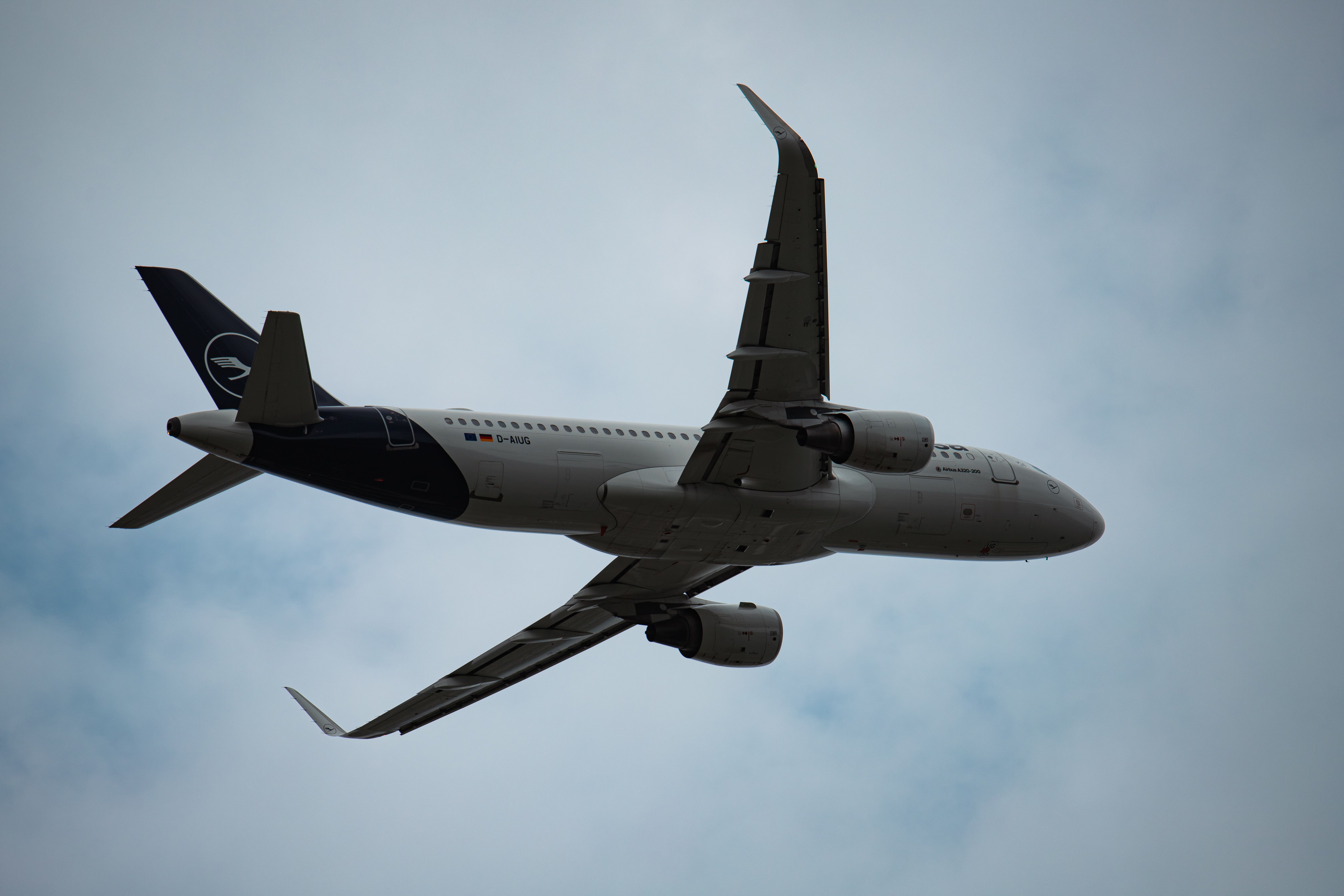 Gratis Et billede af et Lufthansa-fly, der flyver gennem en overskyet himmel i München Lufthavn. Lagerfoto