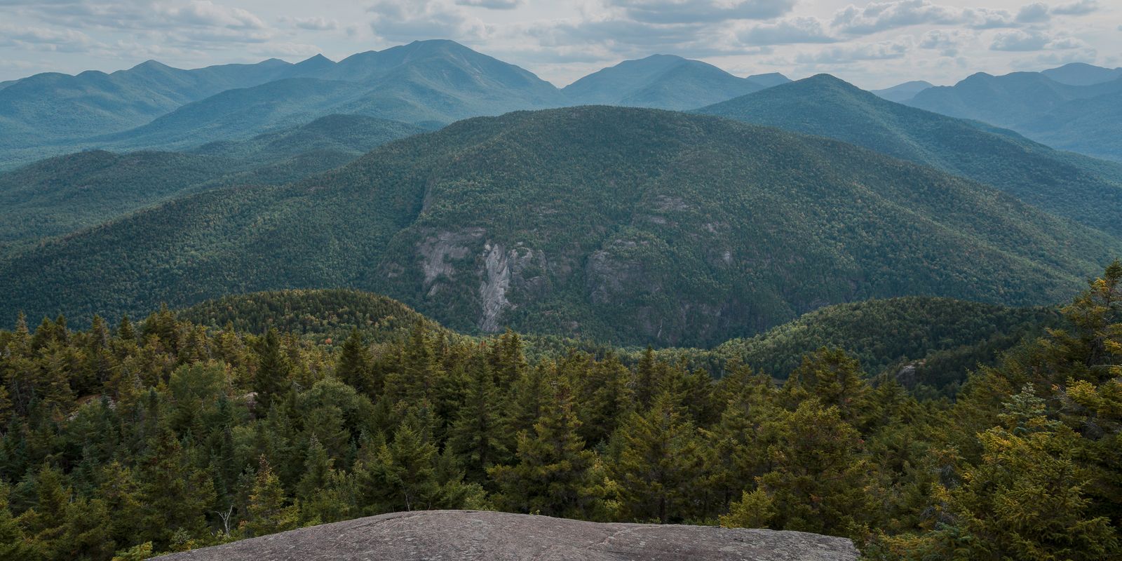 A view of lush forested mountains and a green valley