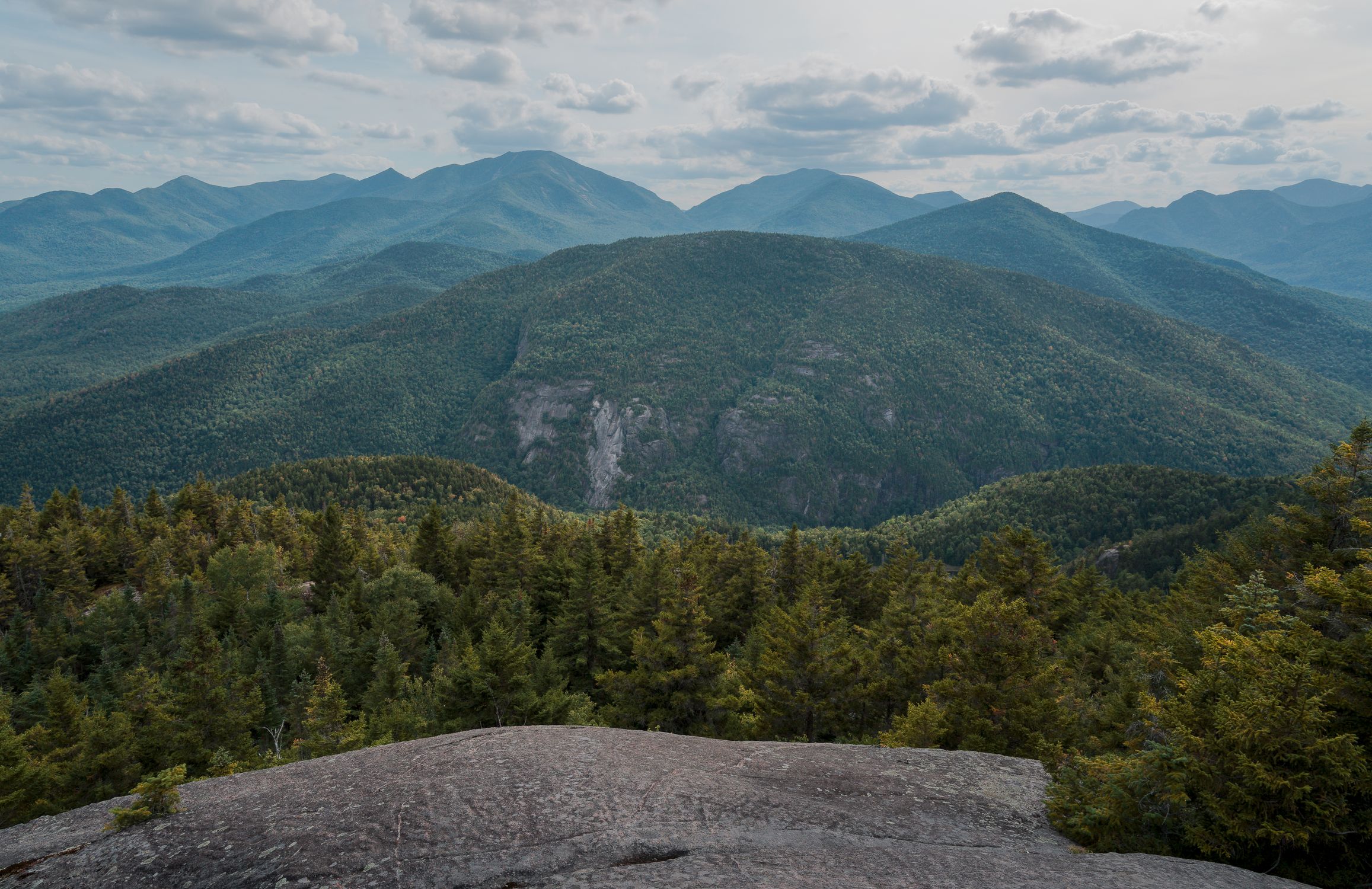 Breathtaking view of the Adirondack Mountains from Keene Valley, showcasing lush forests and mountain peaks.