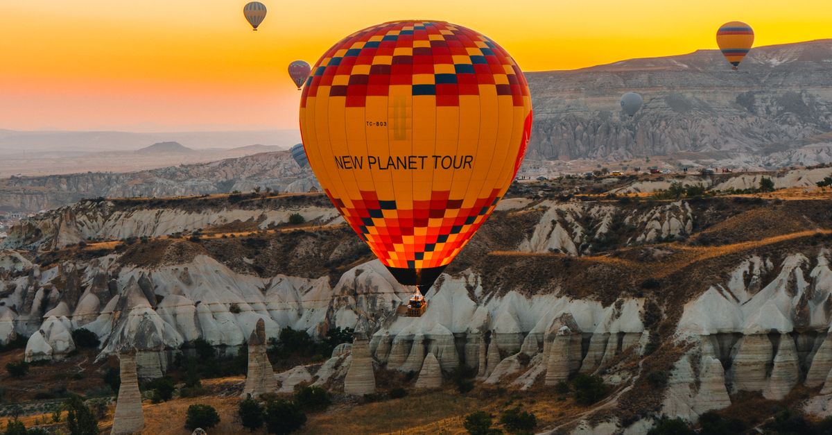 Cappadocia 2026: Hot Air Balloons, Fairy Chimneys & Cave Hotels 10 A majestic hot air balloon drifts serenely over the surreal rock formations of Cappadocia, Turkey, at dawn.