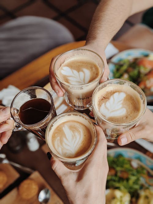 Free People With Four  Drinking Glasses Of Coffee While Making A Toast Stock Photo
