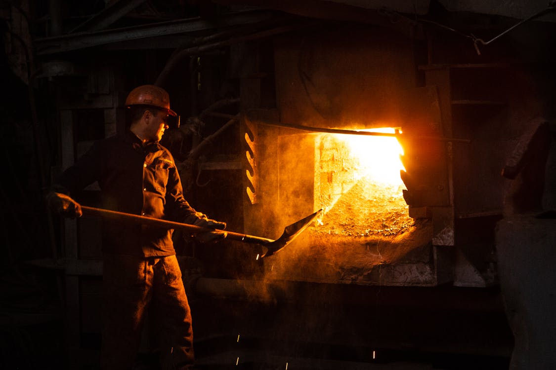 Pekerja dalam Pabrik menggunakan Sekop Api