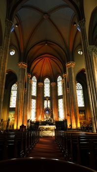 Breathtaking view inside a gothic cathedral with stunning stained glass and warm lighting.