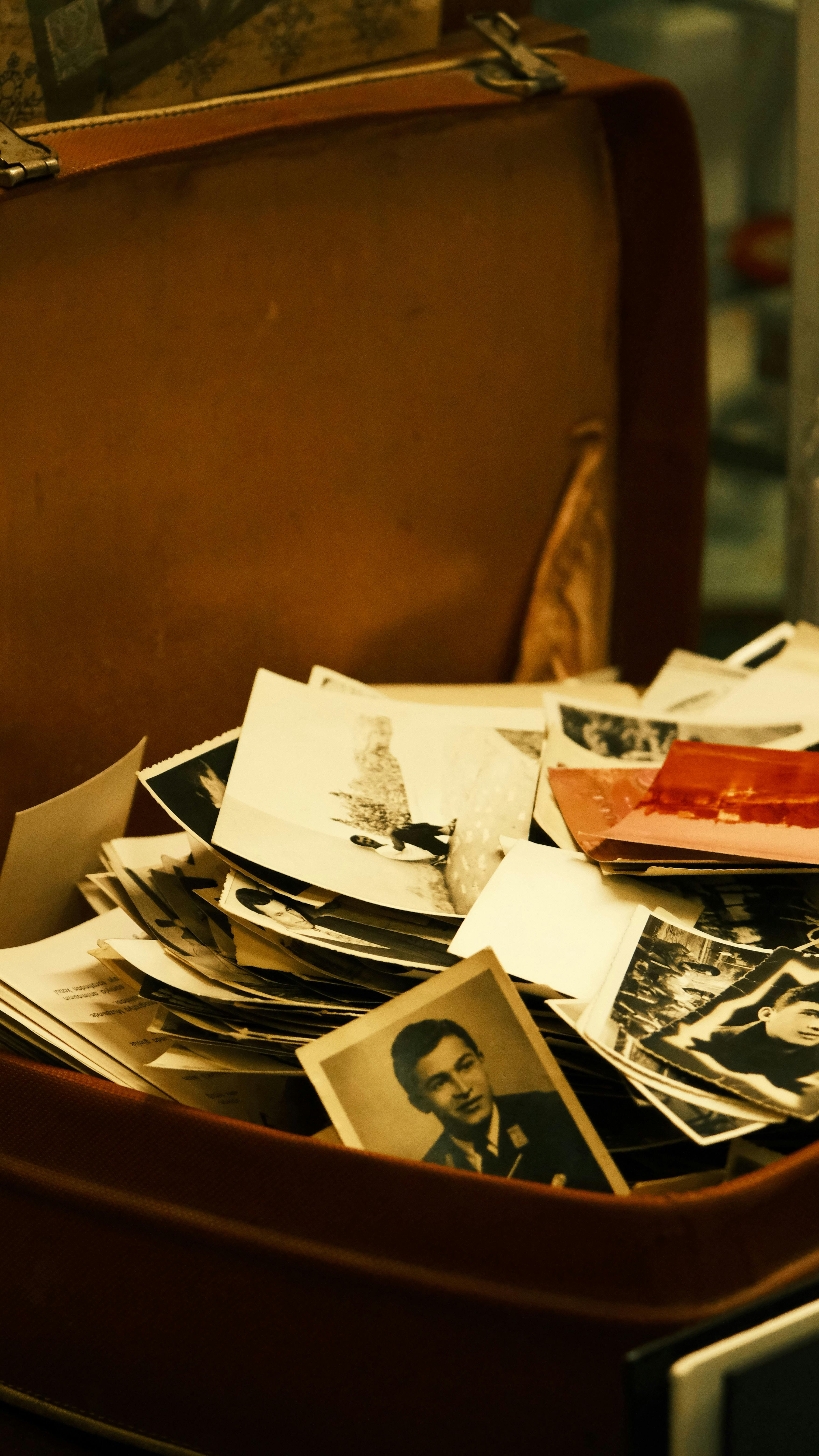 A collection of nostalgic black and white photos in a vintage suitcase.