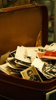 A collection of nostalgic black and white photos in a vintage suitcase.