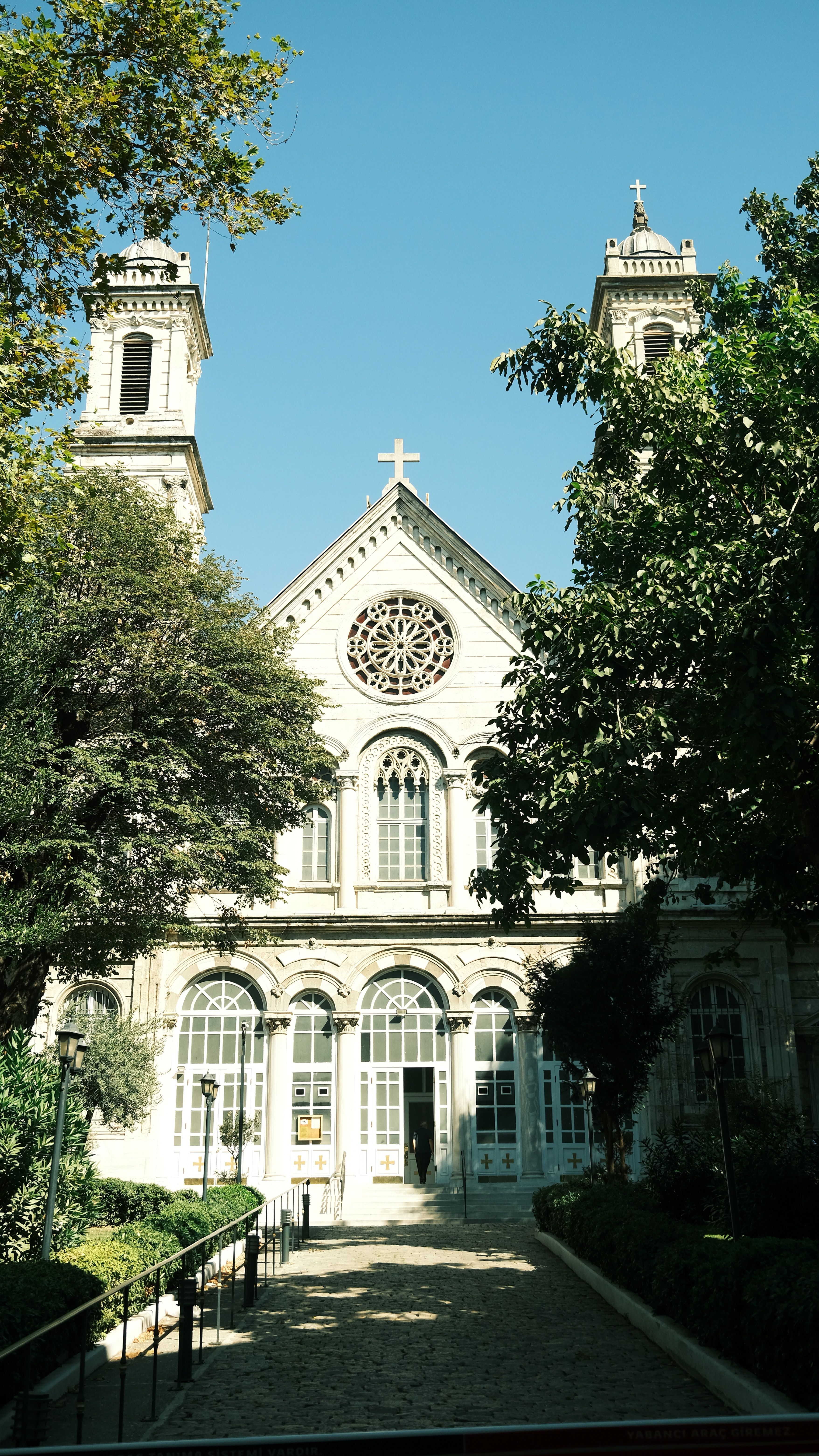 Beautiful view of a historic church facade surrounded by trees on a sunny day.
