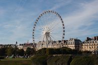 Ferris wheel in Paris offers a scenic view against a clear blue sky.