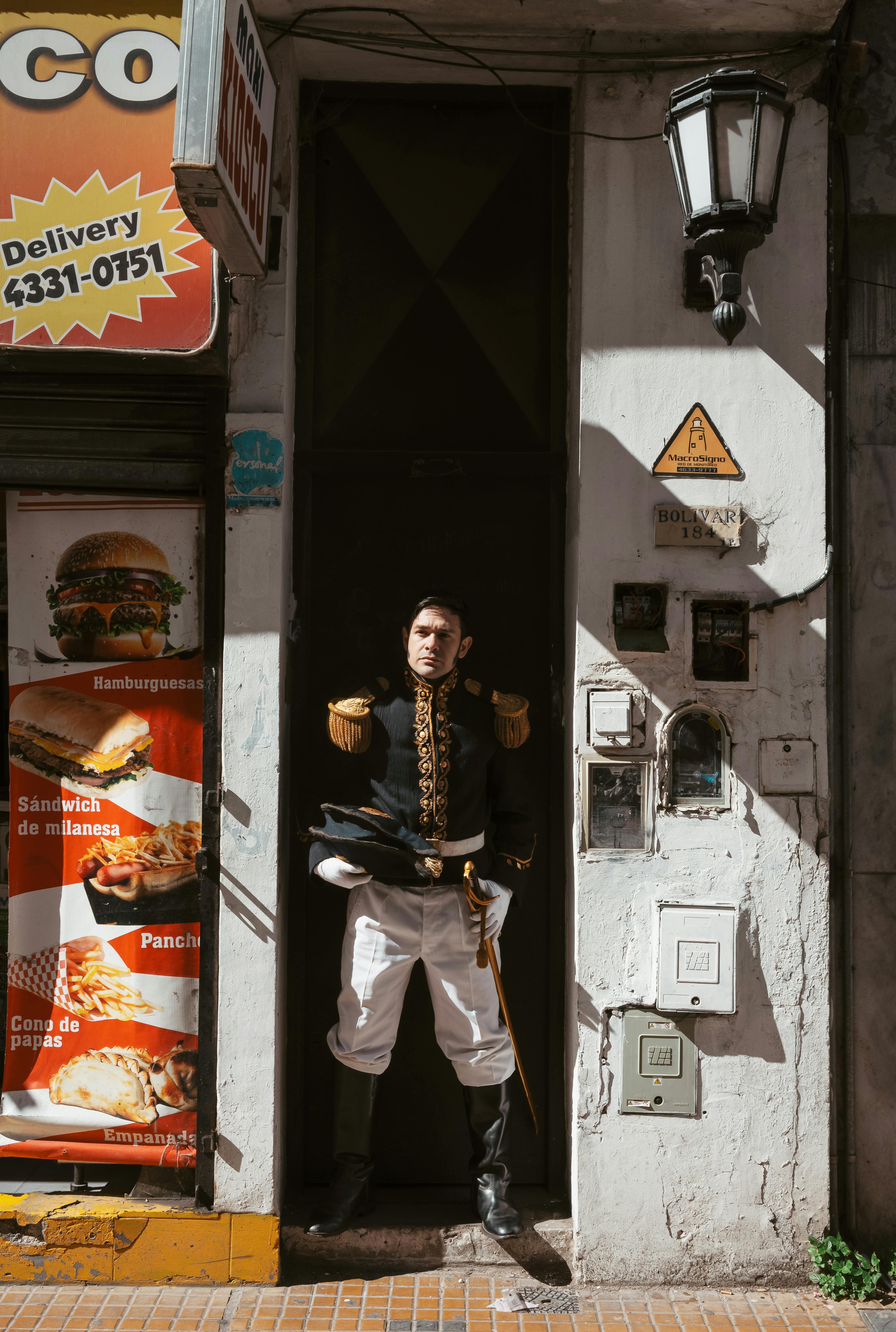 Man in historical soldier costume stands in Buenos Aires street entrance.