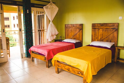 Cozy twin bedroom in Kampala, Uganda with vibrant bedding and a mosquito net, perfect for a tropical stay.