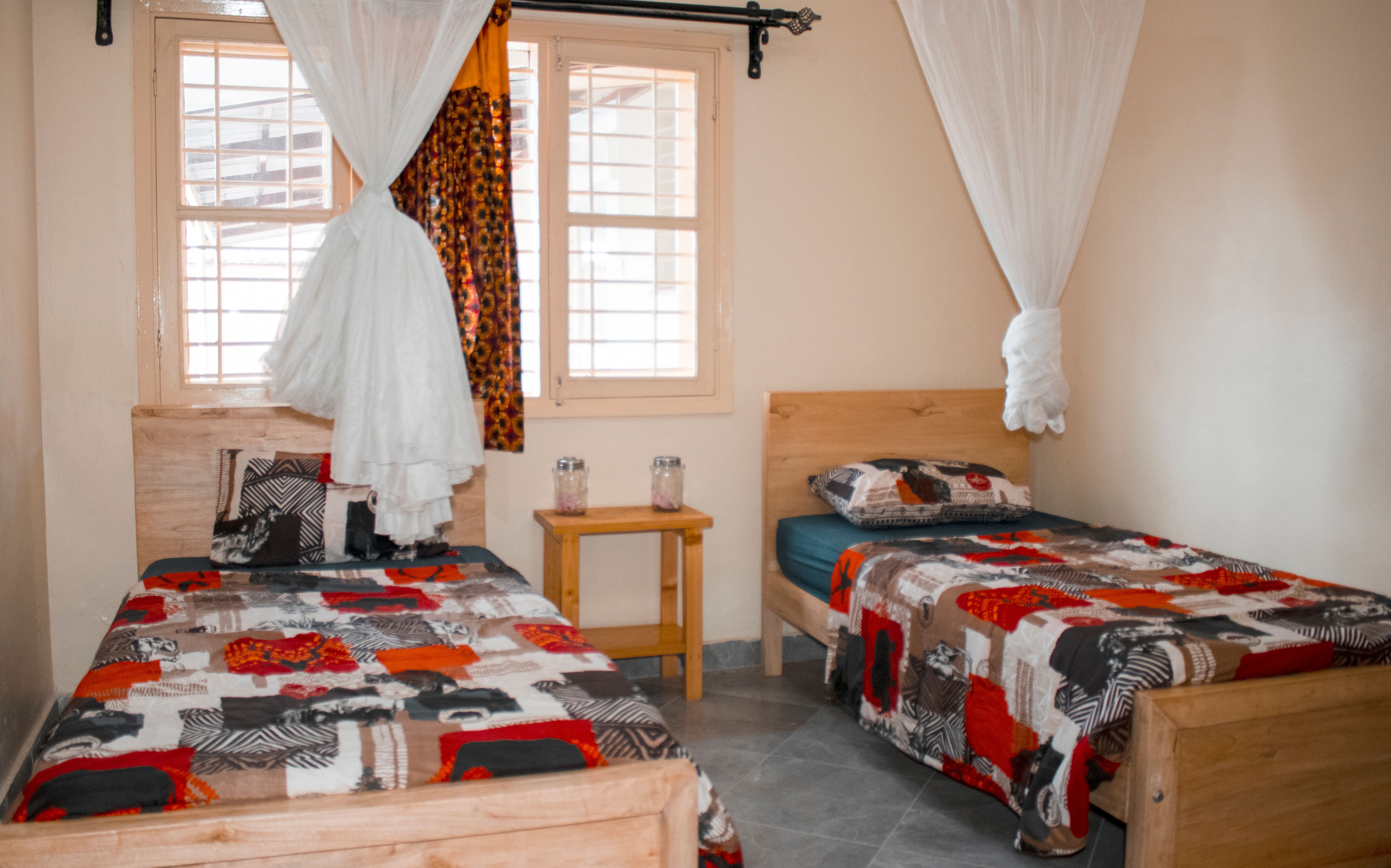 Inviting twin bedroom in Kampala, featuring vibrant bedspreads and a peaceful ambiance. — Maynard Longarm Quilting