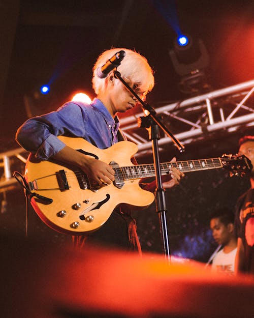 Man Playing Brown Guitar