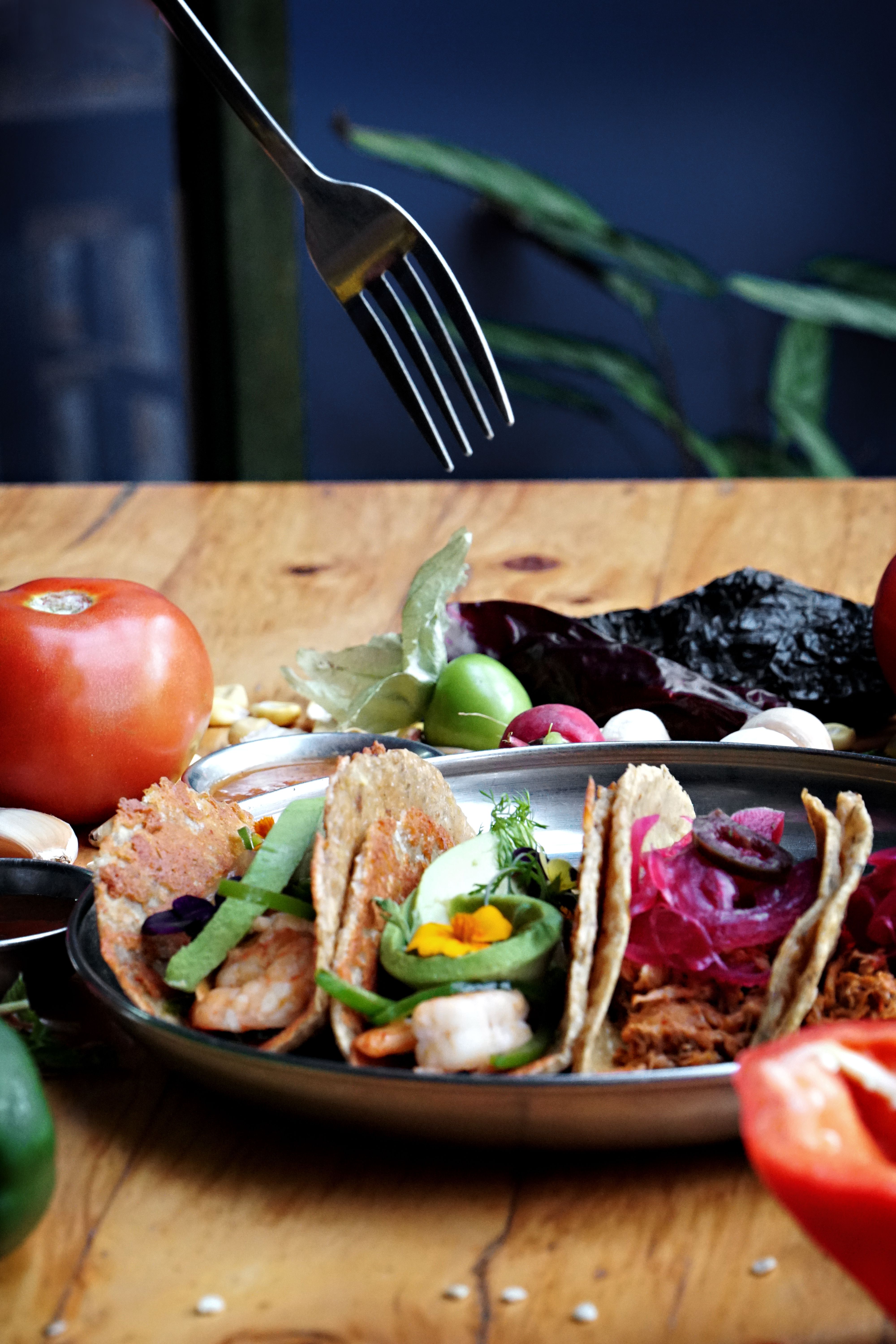 A vibrant display of assorted Mexican tacos garnished with fresh ingredients on a plate.