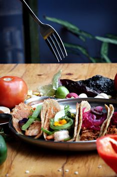 A vibrant display of assorted Mexican tacos garnished with fresh ingredients on a plate.
