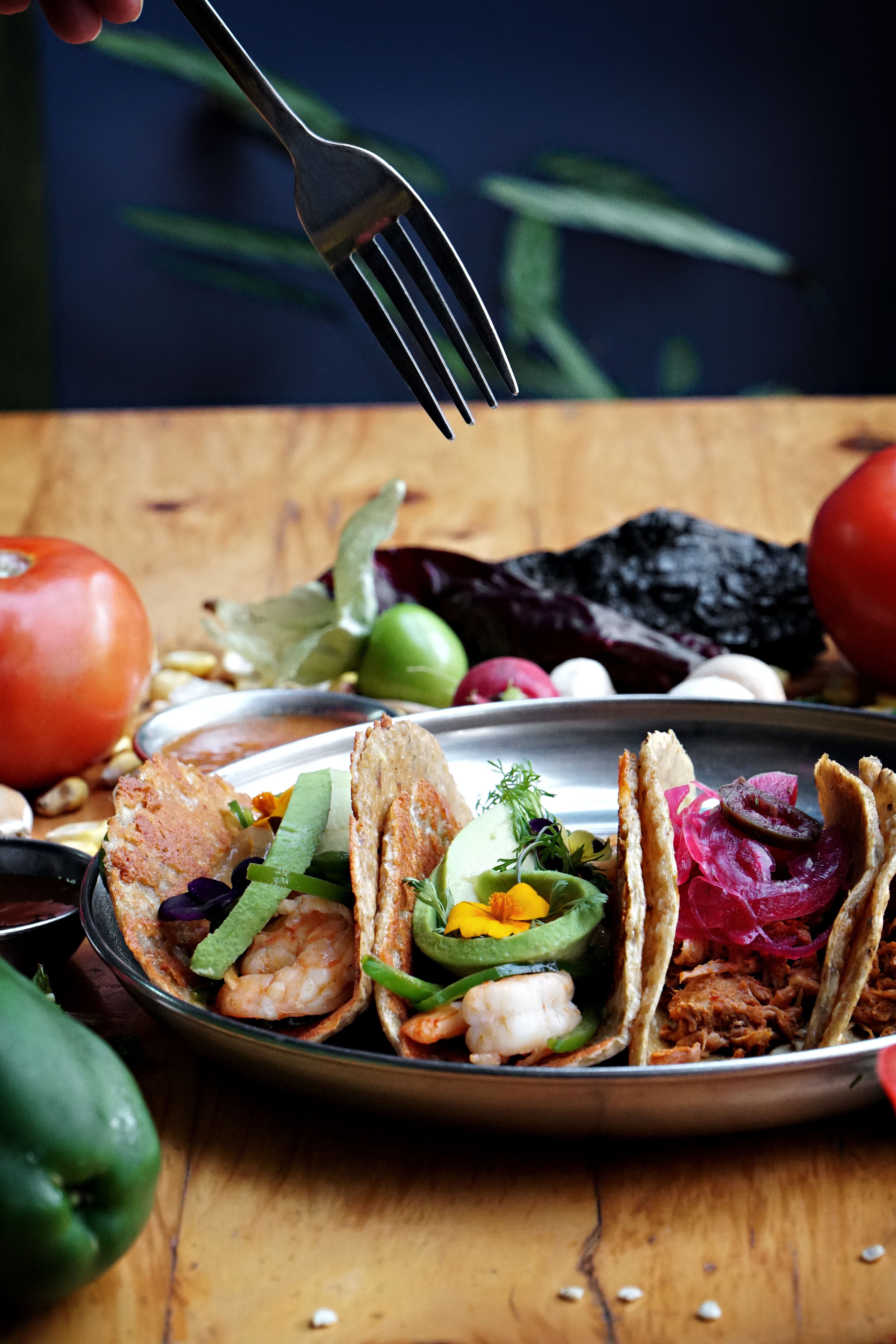 Vibrant display of traditional Mexican tacos with fresh vegetables and herbs, perfect for culinary exploration.
