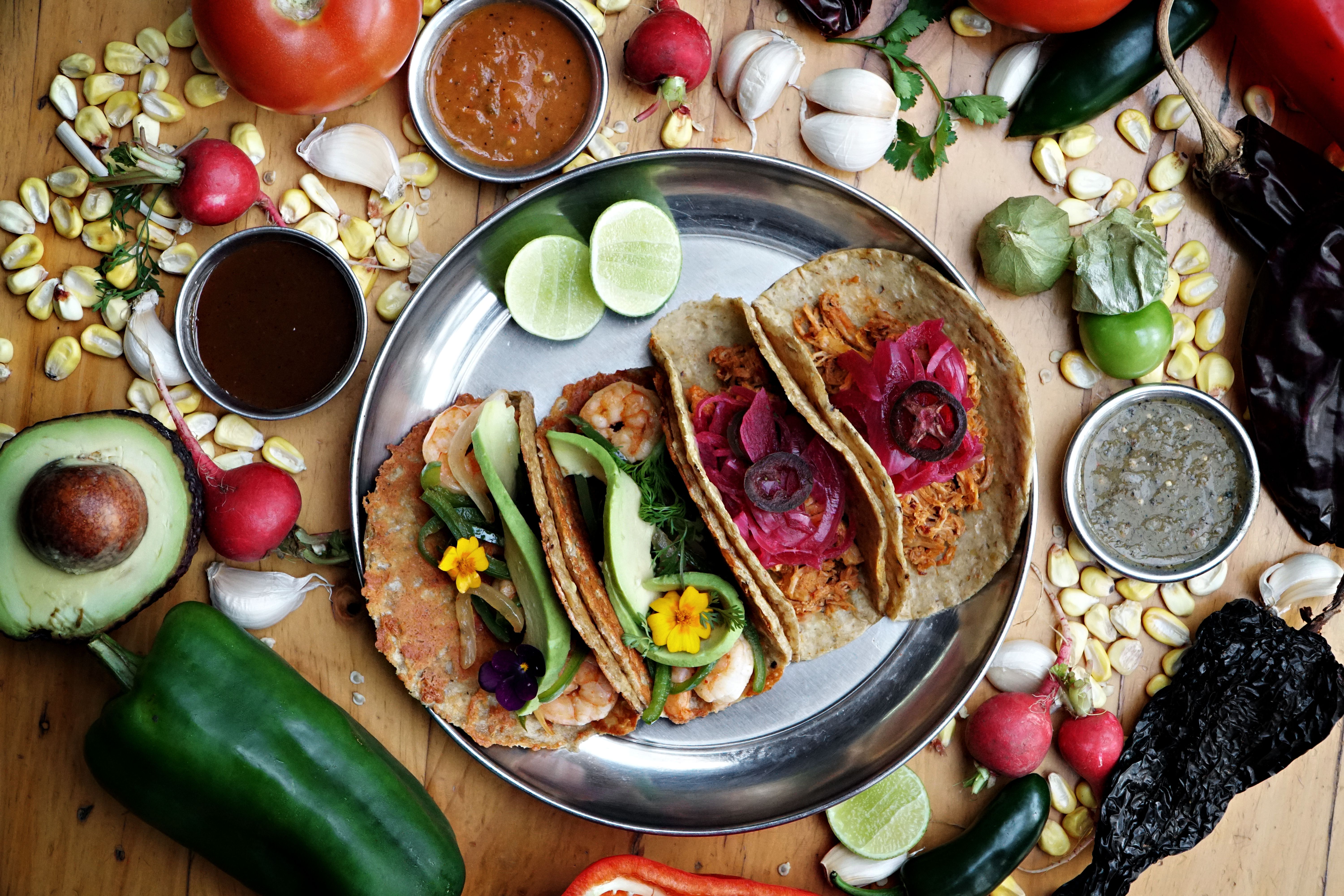 Vibrant display of Mexican tacos with fresh vegetables and sauces, perfect for food blogs.