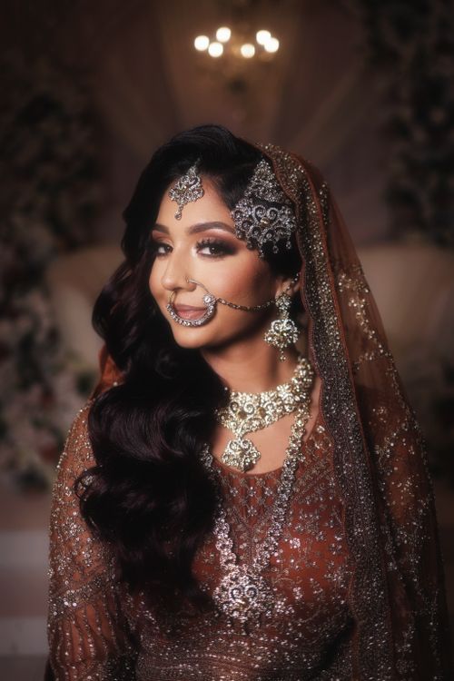 Free Captivating image of a smiling bride adorned in ornate traditional jewelry and attire, exuding elegance and grace. Stock Photo