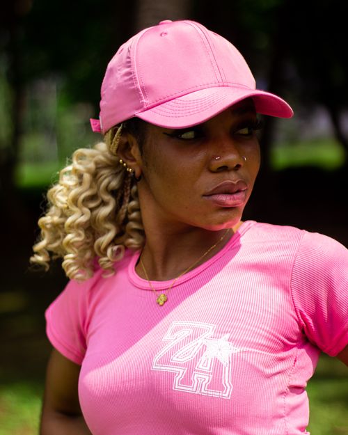 Free Young woman in pink attire posing outdoors with a vibrant expression. Stock Photo