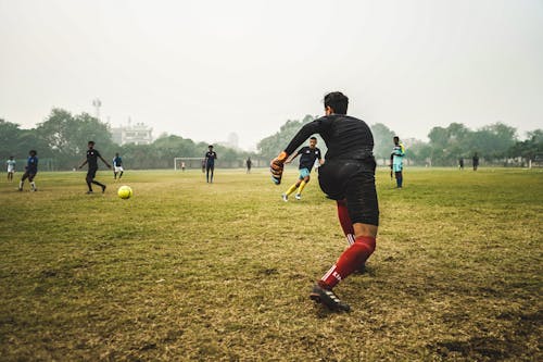 Ücretsiz Gün Boyunca çim Sahada Futbol Oynayan Insanlar Stok Fotoğraflar