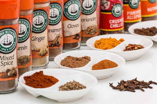 Mixed Spice Bottles on White Surface With Bowls