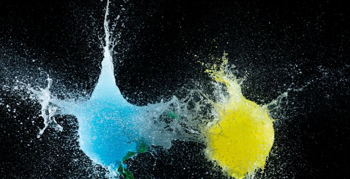 Dynamic splash of blue and yellow water balloons bursting, captured in vivid detail.