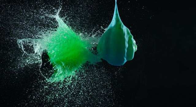 High-speed capture of a vibrant green liquid splash against a dark background.
