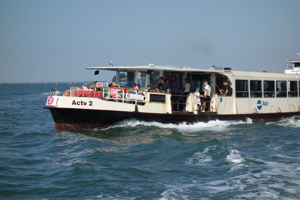 Vaporaș cu turiști traversând laguna venețiană, într-o zi însorită