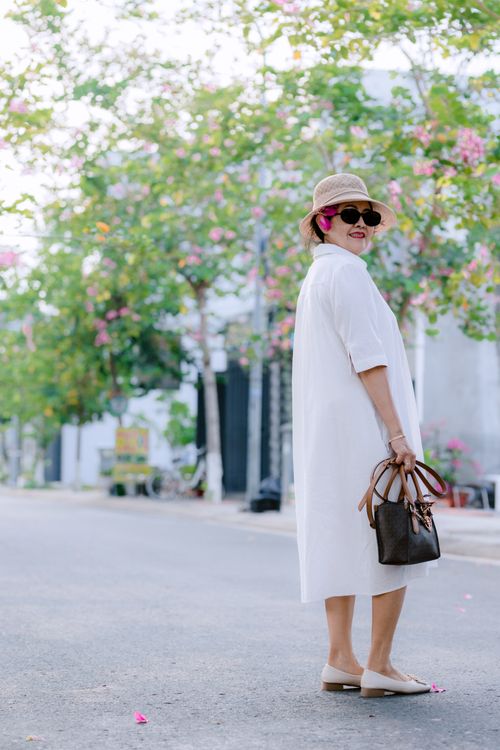 Free Stylish woman with handbag in summer dress and hat outdoors. Stock Photo