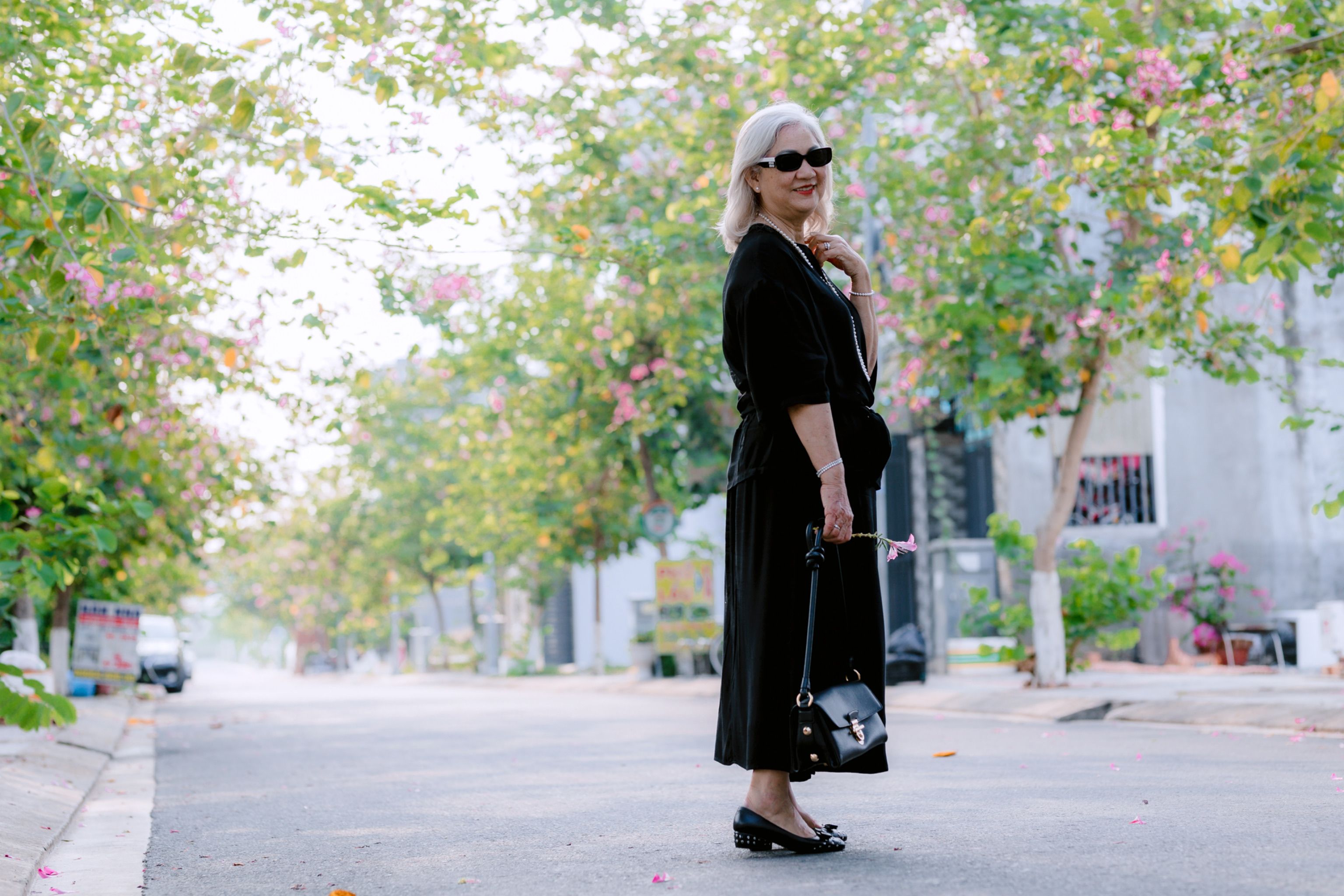 Elegant Woman Walking on Blooming Street · Free Stock Photo