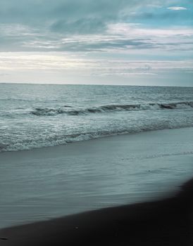 Peaceful beach scene with gentle waves under a moody sky in Los Angeles, CA.