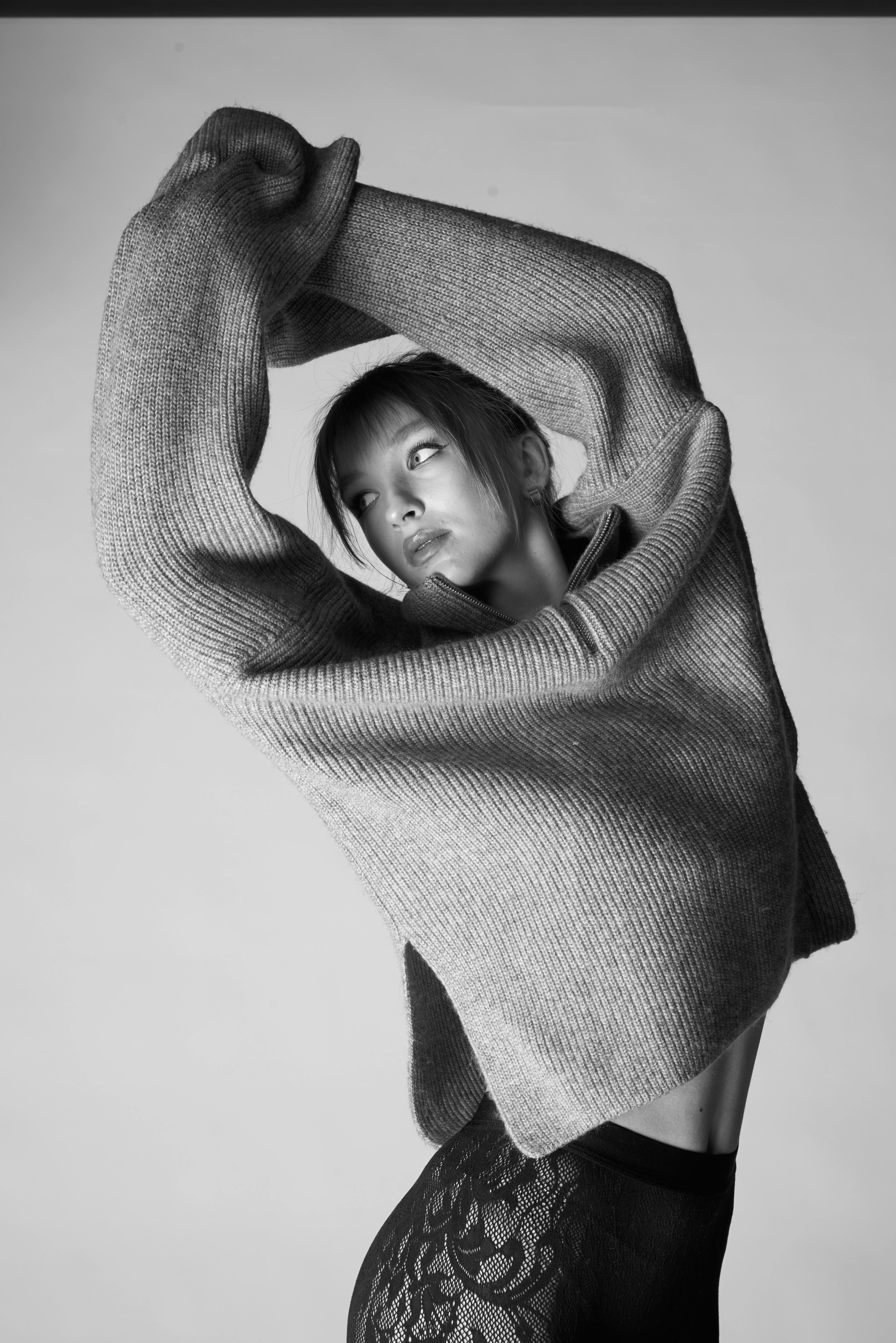 Elegant black and white portrait of an adult woman in a stylish sweater.