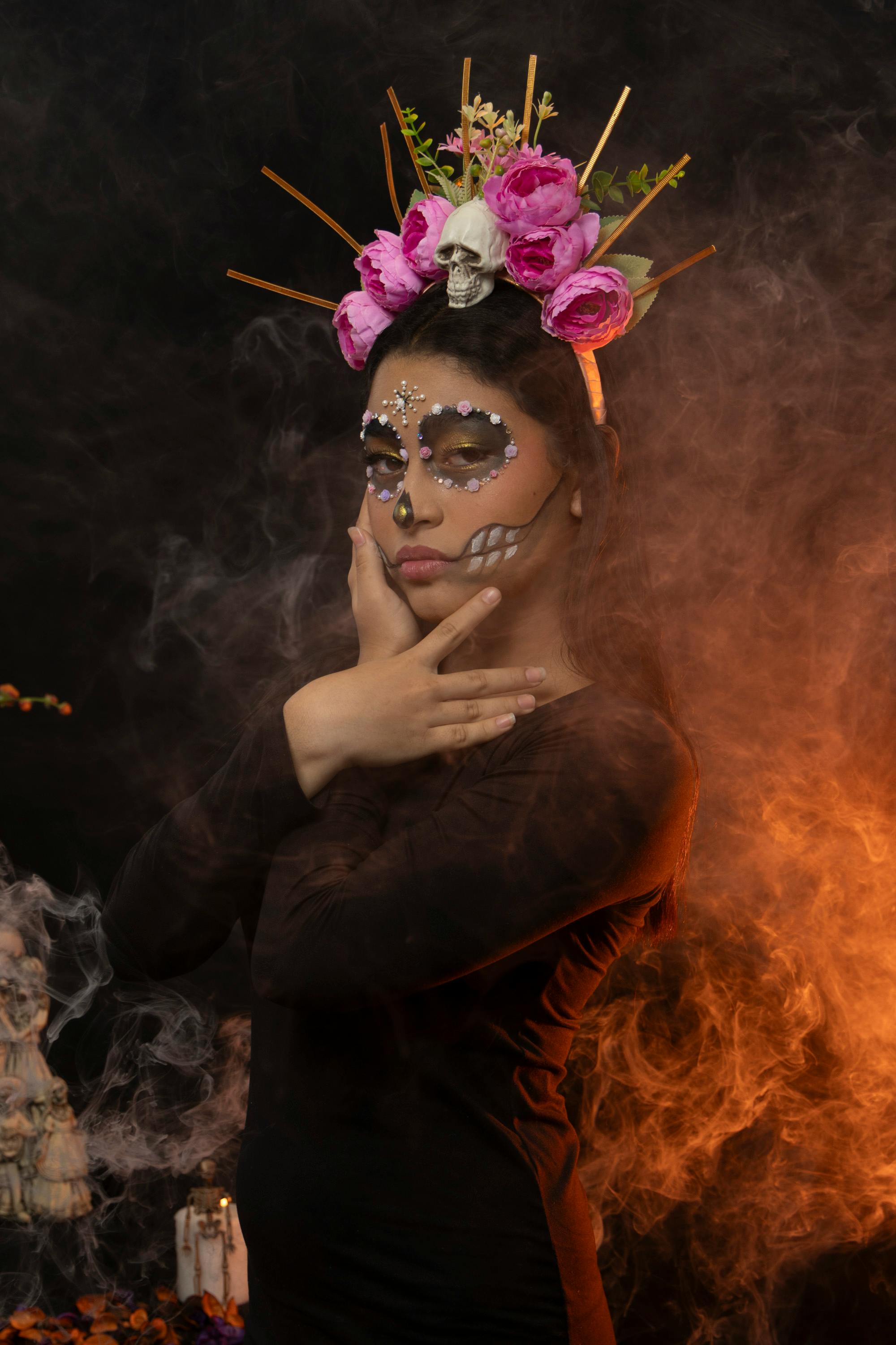 ingyenes Elegáns, Catrina ihlette portré arcfestéssel és virágos fejdísszel, misztikus, füstös háttér előtt. Stockfotó